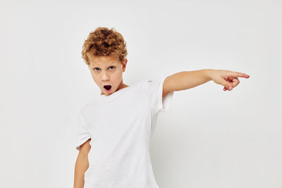 Portrait of boy gesturing against white background
