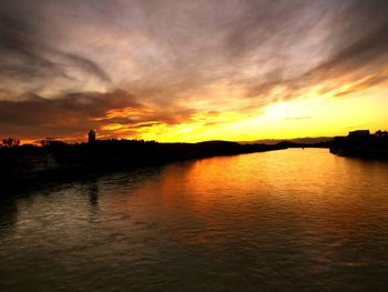 Scenic view of sea against dramatic sky during sunset