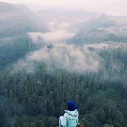 Rear view of woman on mountain over landscape 