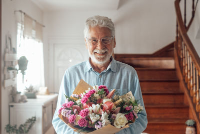 Portrait of man holding flower bouquet