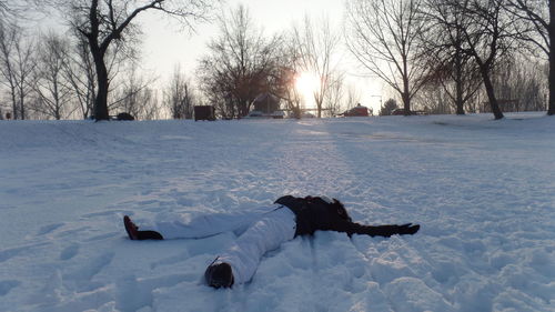 Full length of person lying down on snow covered field