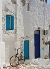 Bicycle leaning against white wall