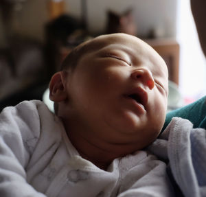 Close-up of baby sleeping on bed