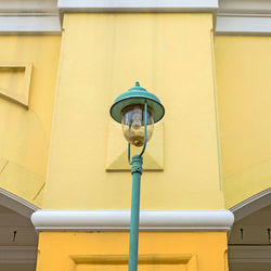 Low angle view of yellow light against building