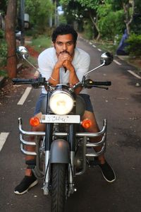 Portrait of man riding motorcycle on road