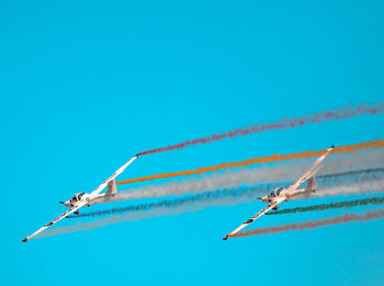 Low angle view of airplane flying against clear blue sky