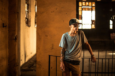 Full length of young man standing against wall