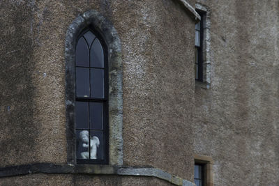 Angel statue seen through glass window of historic building