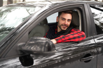 Portrait of smiling young man in car