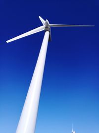 Low angle view of windmill against clear blue sky