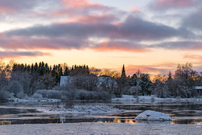 Scenic view of frozen lake against sky during sunset