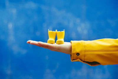 Low angle view of woman holding gift against blue sky