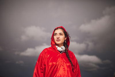Portrait of beautiful young woman standing against sky