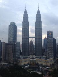 Skyscrapers in city against cloudy sky