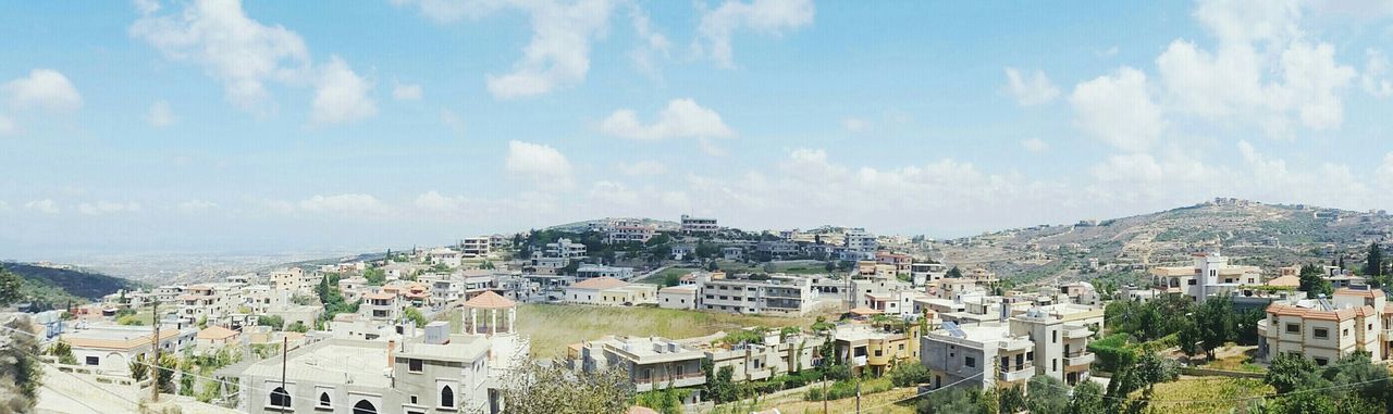 building exterior, architecture, built structure, sky, cityscape, city, residential district, high angle view, residential building, crowded, residential structure, town, cloud - sky, house, townscape, tree, water, cloud, blue, sea