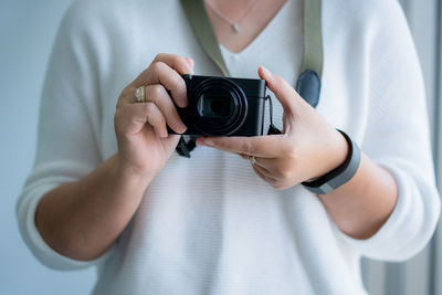 Midsection of woman photographing with camera