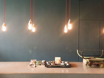 Illuminated light bulbs hanging over table