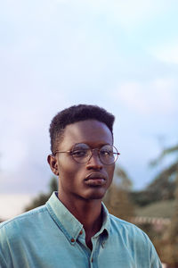 Portrait of young man against sky