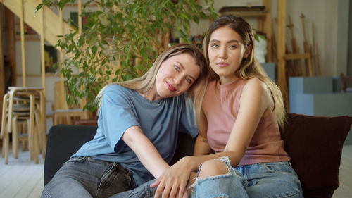 Portrait of smiling couple sitting on sofa at home