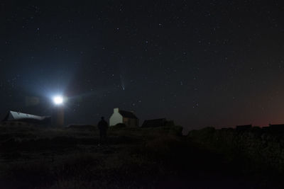 Scenic view of illuminated field against sky at night