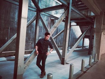 Full length portrait of young man standing on steps