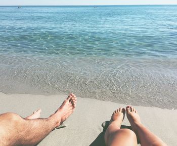 Low section of people relaxing on beach