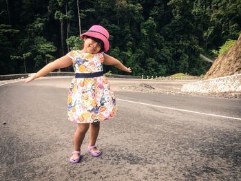 Full length portrait of girl standing on road