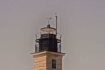 Low angle view of lighthouse against building against sky