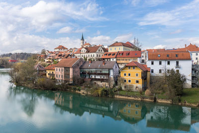 Reflection of buildings in river against sky