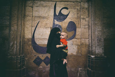 Full length of mother and son standing on floor