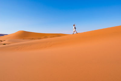 Scenic view of desert against clear blue sky