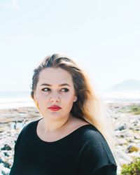 Close-up of young woman looking away at beach