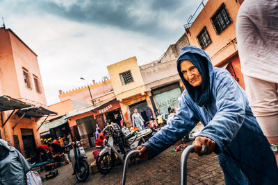 People riding motorcycle against sky in city