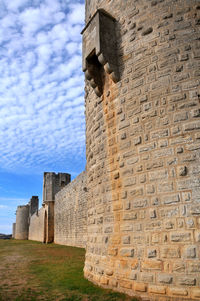 Low angle view of old ruin building against cloudy sky