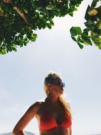Low angle view of woman standing against sky