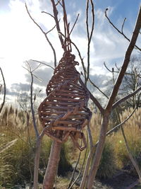 Close-up of metallic structure on field against sky