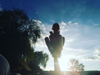 Low angle view of man standing by tree against sky