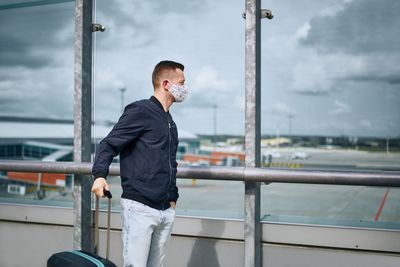 Man standing by railing against bridge