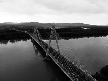 Bridge over calm river against sky