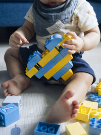 Baby playing with blue and yellow lego bricks