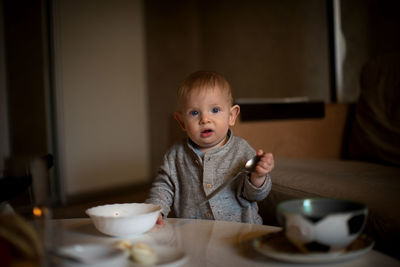 Portrait of cute boy having food at home