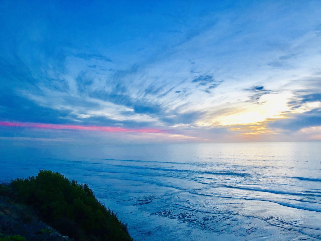 SCENIC VIEW OF SEA AGAINST BLUE SKY DURING SUNSET