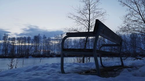 Built structure by frozen lake against sky during winter