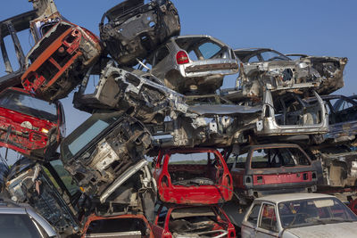 Abandoned cars in junkyard against clear sky
