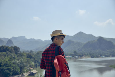 Man standing by mountain against sky