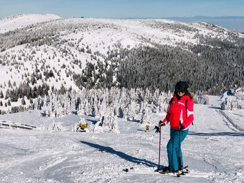 Full length of woman skiing on snowcapped mountain