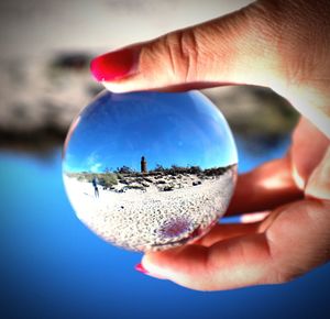 Close-up of hand holding crystal ball