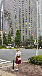 Rear view of woman walking on street against buildings