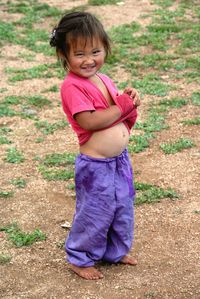 Portrait of a smiling girl standing on field