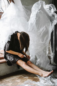 Woman sitting with face down by plastic